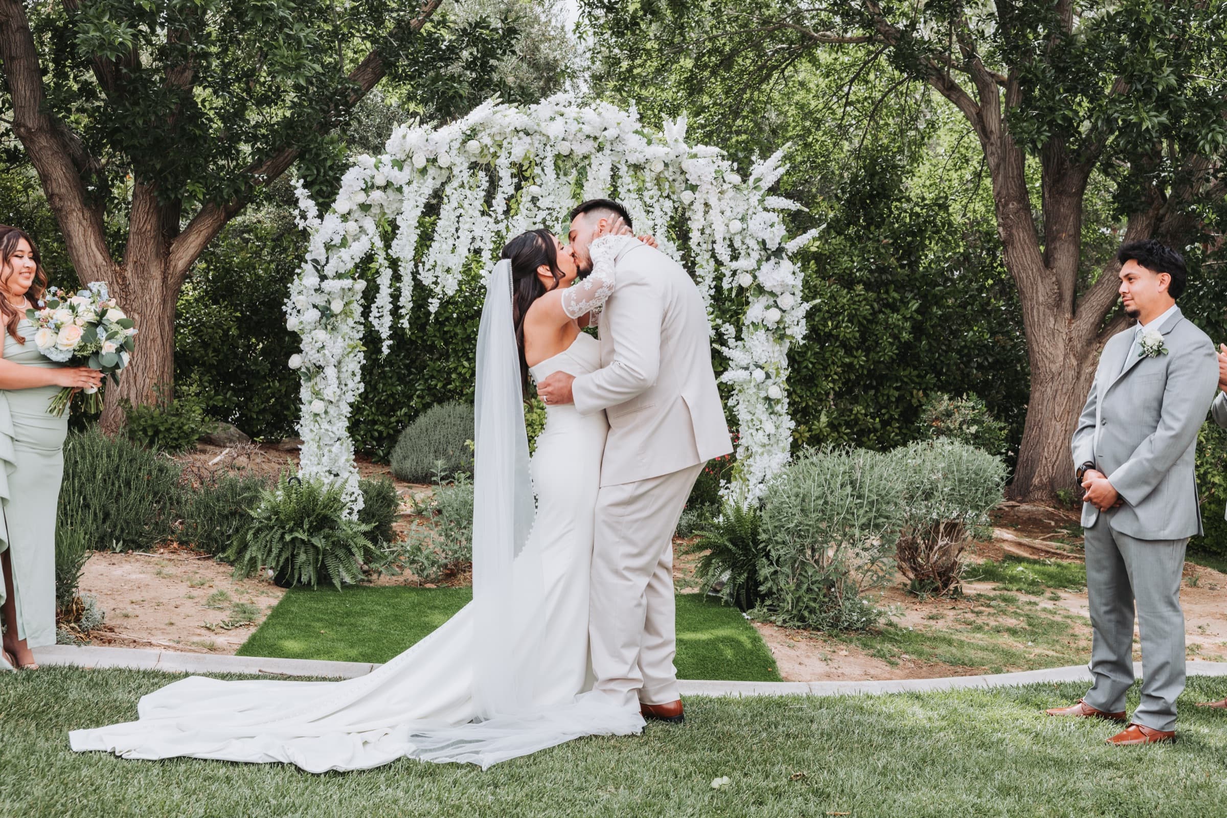 Valeria and Roberto's outdoor ceremony under a white wisteria arch, photographed by VowDeLune